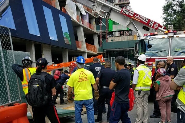 Crews watch the scene after a crane accident on 126th Street in June 2018.